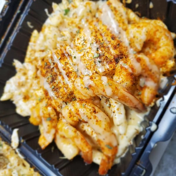 Goldie's Seafood Bar & Grill's shrimp and macaroni and cheese, topped with seasoning and sauce.