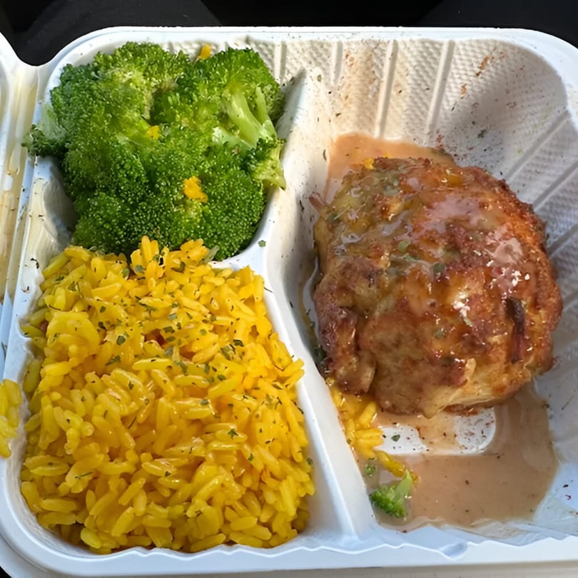 Goldie's Seafood Bar & Grill's takeout meal with broccoli, yellow rice, and a seafood patty.
